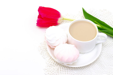 marshmallows, tea or coffee with milk and a tulip flower. on a light background. delicate breakfast, breakfast in bed. for the beloved. Surprise.