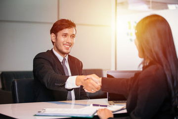 Business people shaking hands and smiling their agreement to sign contract and finishing up a meeting