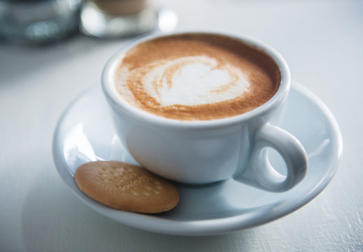 Latte with cookie in a restaurant setting