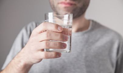 Caucasian man holding glass of water.