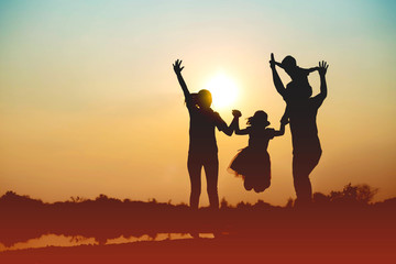 Silhouette of a family comprising a father, mother and two children happy family the sunset.Concept...