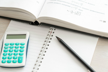 calculator a pencil and a book with the formulas