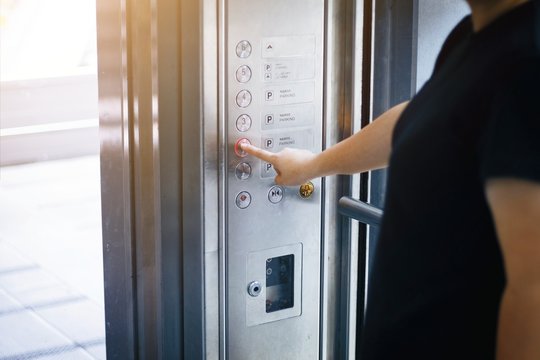 Woman use finger presses the elevator button