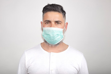 Coronavirus, a man with a medical mask on a white background. Title on the outbreak of the crown virus, disease. Epidemic