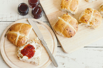 Traditional Easter morning breakfast: homemade hot cross buns with jam and butter