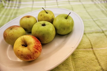 apples in a bowl on wooden table