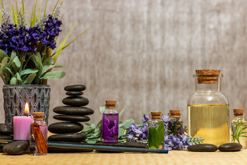 Obraz na płótnie Canvas Composition of the spa treatment, candles. Bottles of essential oil with dried rose petals, chamomile, calendula and incense resin on a Bamboo mat
