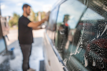 man cleaning car with yellow sponge. carwash concept