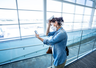 Coronavirus outbreak travel restrictions. Traveler with mask at airport affected by travel ban and flight cancellations and Borders shutdowns.