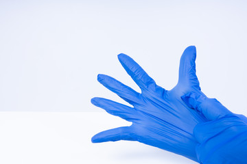 Hands putting on blue nitril gloves