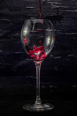 Red wine in a glass on a black background.