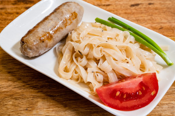 grilled sausage, noodles, tomato and onion 