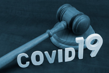 Wooden judge gavel with word covid19. Concept of quarantine and law against covid-19.	