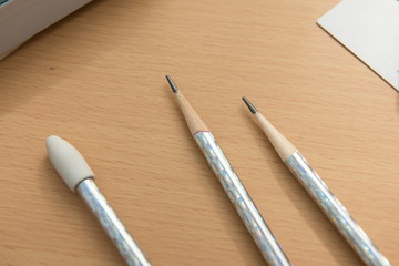 All kinds of lovely children's pencils are collected by the sun on the wooden table