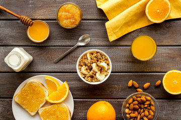 Granola for healthy breakfast. Still life composition with fruits and toast on wooden background top-down