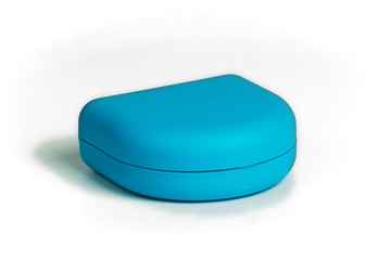 Blue carrying case for orthodontic retainer made from transparent plastic  isolated on white. Retainer for aligning teeth.