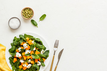 Vegeterian meal concept. Salad with pumpkin and basil on white background top-down copy space