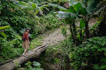 Naklejka na ściany i meble woman crossing a bridge in jungle