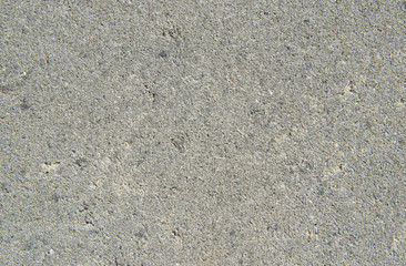 Light gray sand texture. Background with small interspersed grains of sand grains close-up. Rough concrete surface