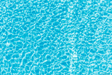Surface of blue shining swimming pool water ripple and sun reflection. Perfect as a background for summer, vacation, calmness, serenity or any other idea.