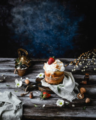 Easter cake with baked meringue on wooden table among spring herbs  with shabby blue backside