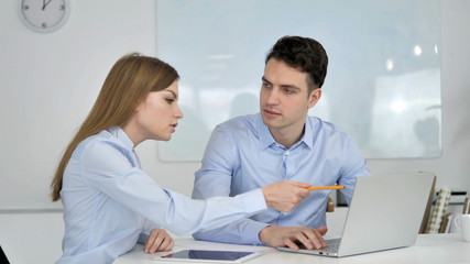 Two Young Business Colleagues Working Together on Project