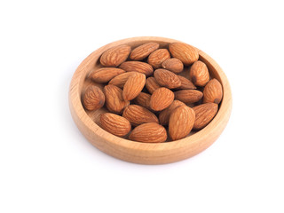 Almonds in wooden plated isolated on white background. 