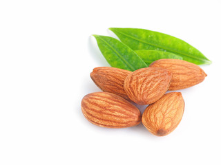 A pile of almonds seed with leaves isolated on white background.