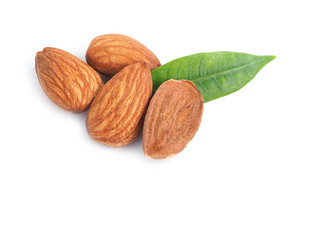A pile of almonds seed and half with leaves isolated on a white background.
