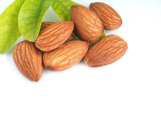 A pile of almonds seed with leaves isolated on a white background.