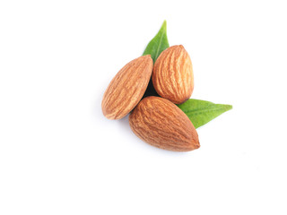 A pile of almonds seed with leaves isolated on white background. 