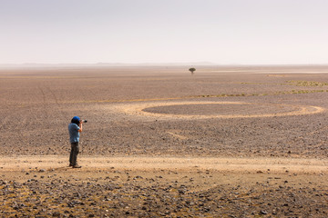 Fototapeta na wymiar Photographer taking pictures of desert Sahara, Morocco