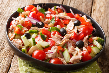 Italian salad with tuna, fresh vegetables and beans close-up in a plate. horizontal