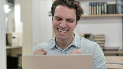 Creative Man Celebrating Success while Working on Laptop