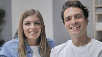 Smiling Young Couple on Couch