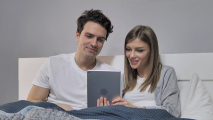 Young Couple in Bed Doing Online Video Chat via Tablet