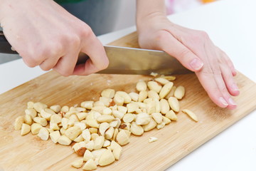 sliced almonds with a knife wooden kitchen board