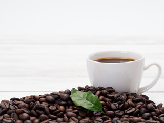 Roasted coffee beans with coffee leaves.