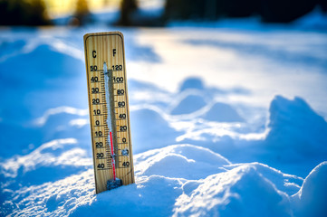 Winter. Thermometer on snow shows low temperatures.