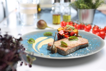 Obraz na płótnie Canvas Grilled tuna steak with fried vegetables and parsley mousse.A plate with an appetizing dish. Application suggestion. Culinary photography, food stylization.