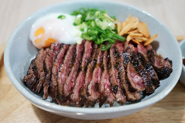 Close up Sliced medium rare Wagyu beef served on rice and topped with poached egg