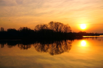 Fototapeta na wymiar A wonderful Golden sunrise over the river with trees in spring.