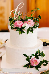 white cream cake decorated with roses and the inscription love
