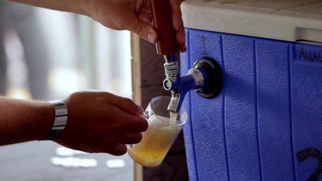 Draft beer being poured into a glass from a beer tap
