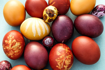 Easter background, multi-colored chicken and quail eggs on bright blue background.