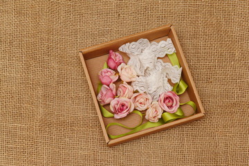 a few roses and a green ribbon in a box