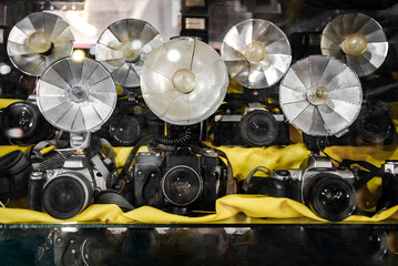 Old folding fan camera flash reflectors with flashbulbs on old cameras taken with shallow depth of field.