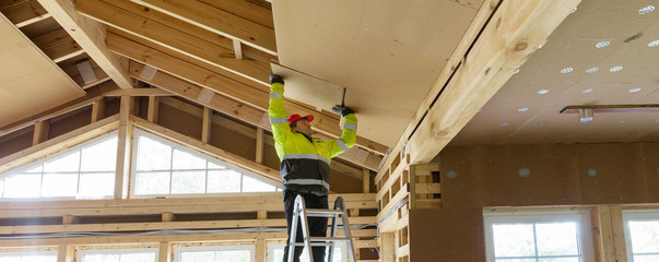 Construction worker thermally insulating eco wooden frame house