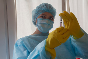 Woman doctor in protective clothing and a mask in the laboratory. Medicine