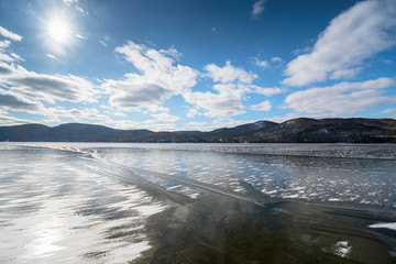 Frozen lake and mountains in late winter seen from Willsboro Point NY.